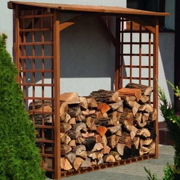 Rangement pour le bois de chauffage contre le mur de la maison